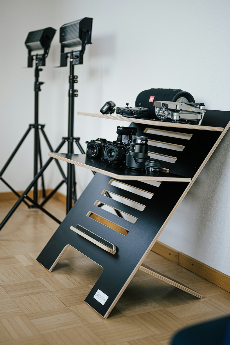 Cameras and drone on a modern wood and black desk.